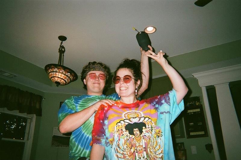 Two people taking a picture in hippie costume