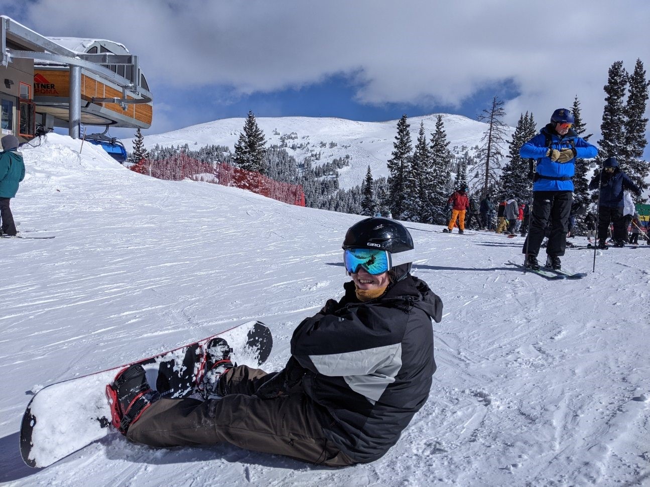 Harrison snowboarding and sitting in the snow