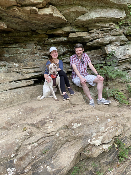 People and dog sitting on rocks