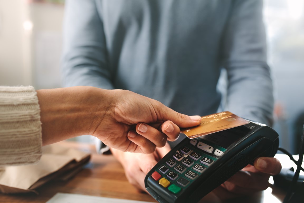 A person is taping their credit card to pay at a business
