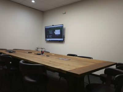 Technical Resource Solutions conference room with tv and a big wooden table